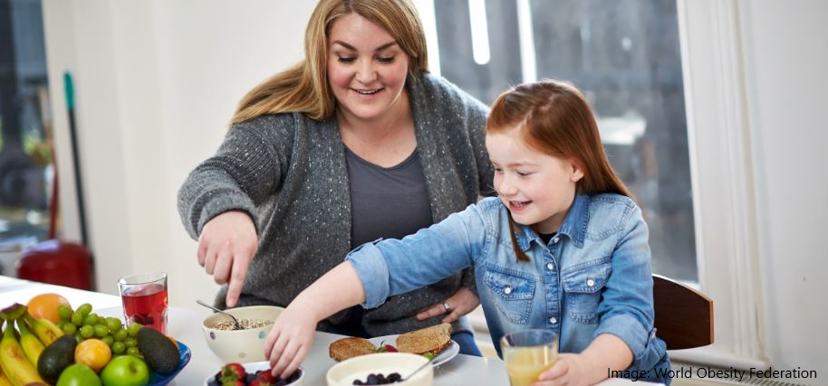 a mother and daughter select healthy foods from a selection of fruits and grains