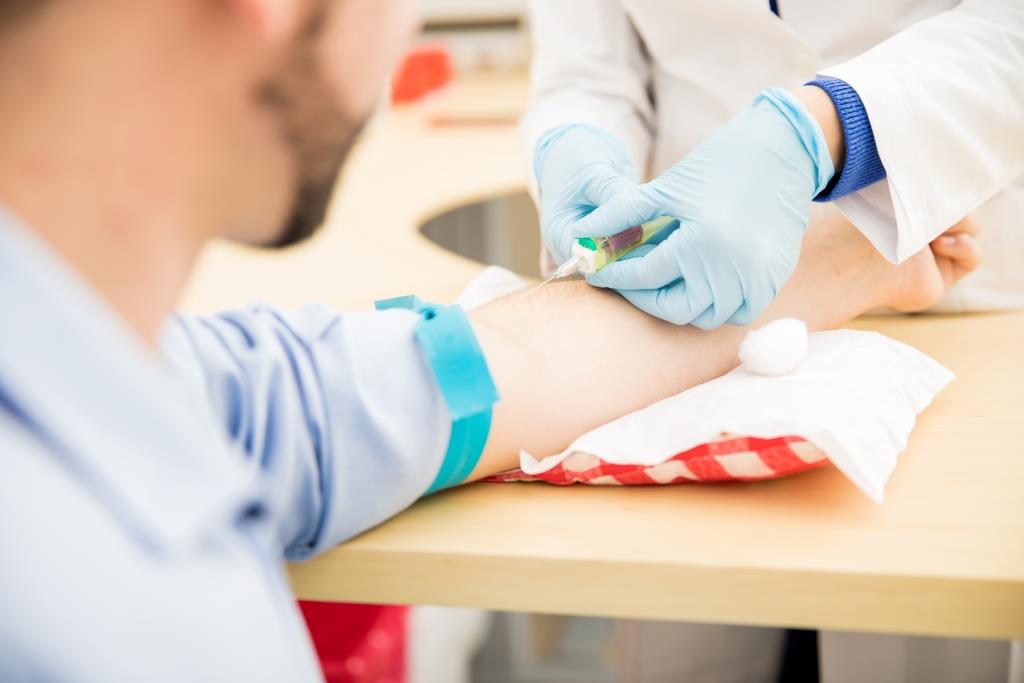 physician drawing blood from male