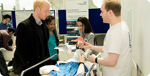 a researcher speaks to members of the public at their exhibition stand