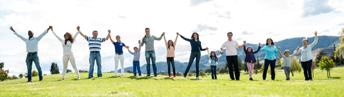 Happy group of people holding hands outdoors